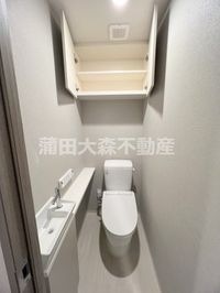 吊戸棚と手洗い、温水洗浄便座付きのトイレ