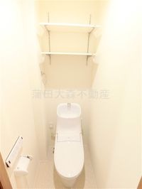 棚と温水洗浄便座付きのトイレ