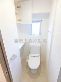 窓と棚収納+温水洗浄便座付きのトイレ