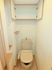 上部棚収納と温水洗浄便座付きのトイレ