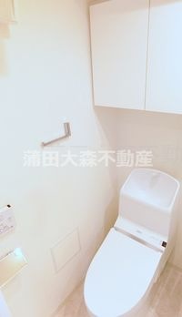 棚収納と温水洗浄便座付きのトイレ