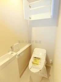 棚と温水洗浄便座付きのトイレ