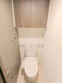 吊戸棚と温水洗浄便座付きのトイレ